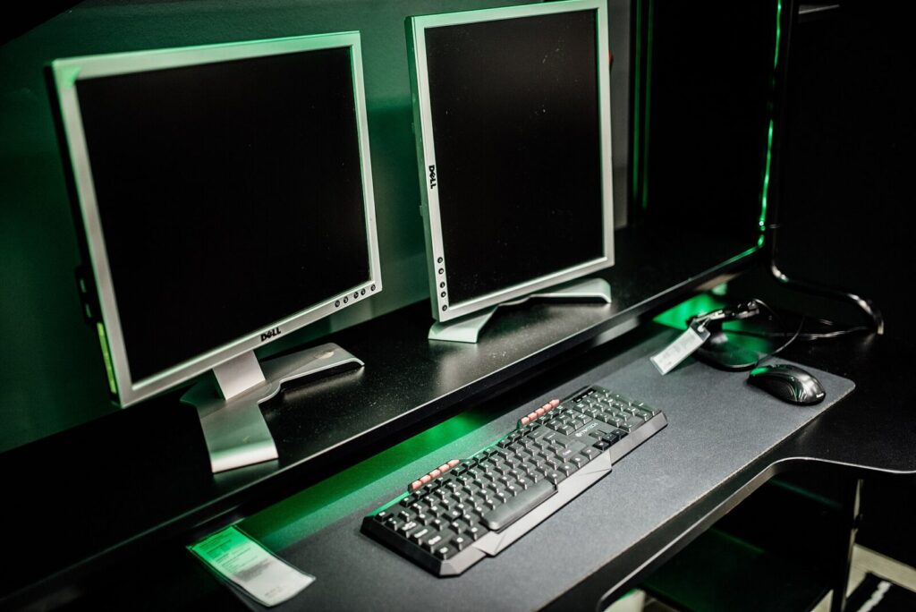 Escritorio gamer con monitores, teclado y mouse iluminados
