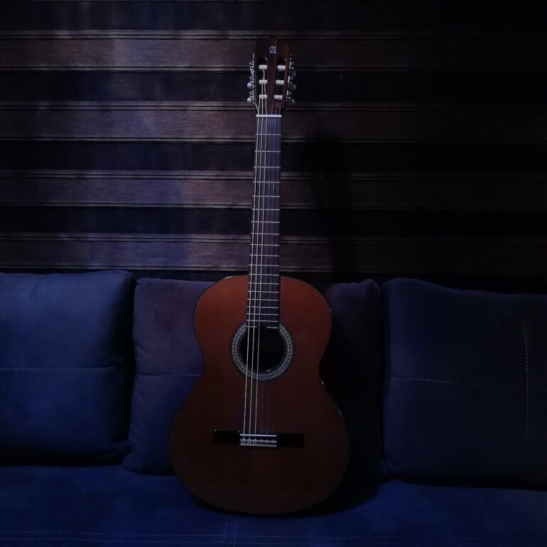 Guitarra criolla apoyada en un sillón