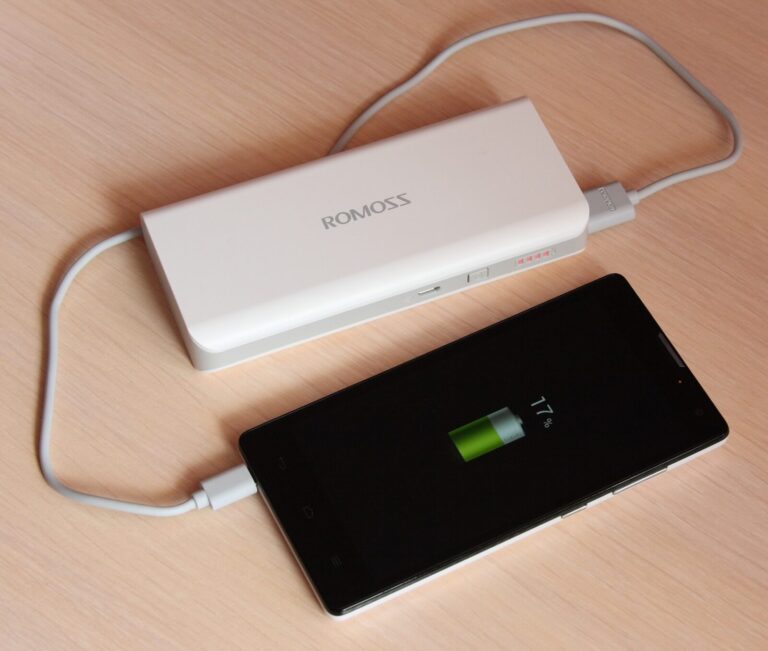 Power bank portátil cargando un celular con cable